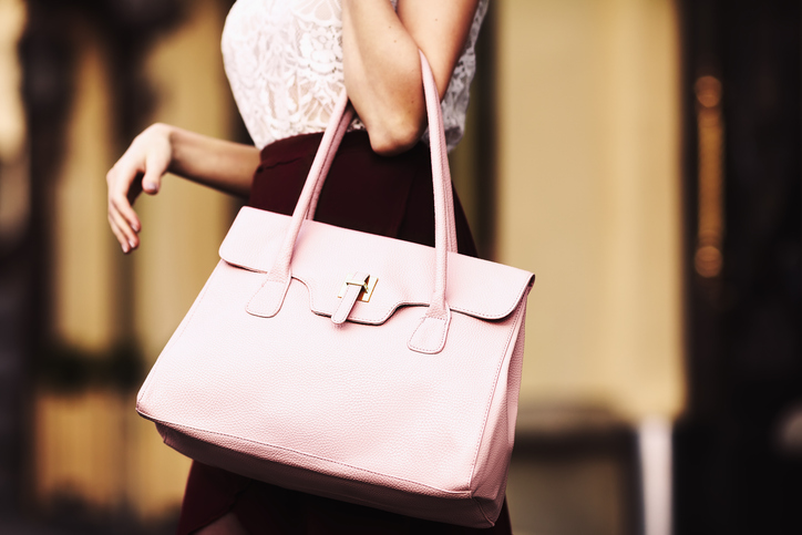 elegant outfit. closeup. leather bag in hands of stylish woman